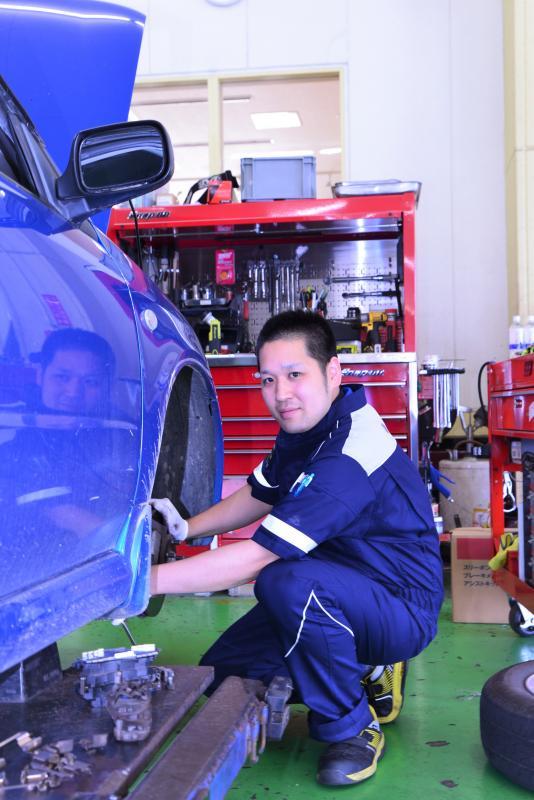 福島スバル自動車整備工場で修理作業をする圓谷謙太さんの写真