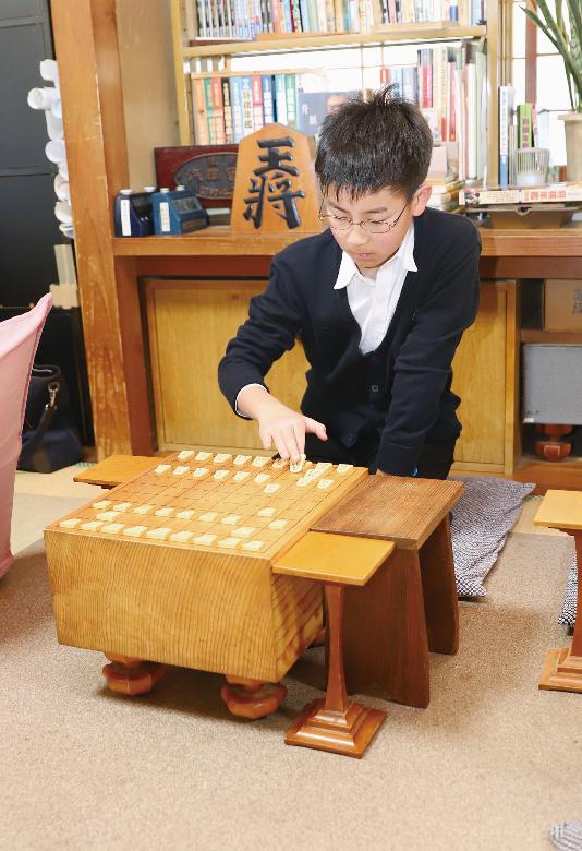 古川雅也さんが盤面で将棋を指している写真