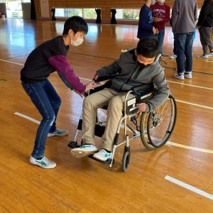 車いすに乗る男子児童とそれを手伝う男子児童の様子