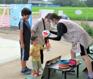 夏まつりでドラえもんのお面をもらっている男児