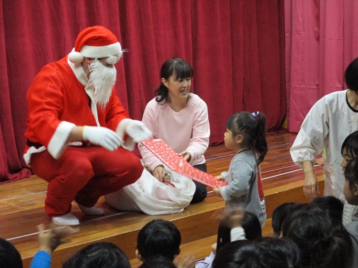 サンタクロースからプレゼントをもらう子ども