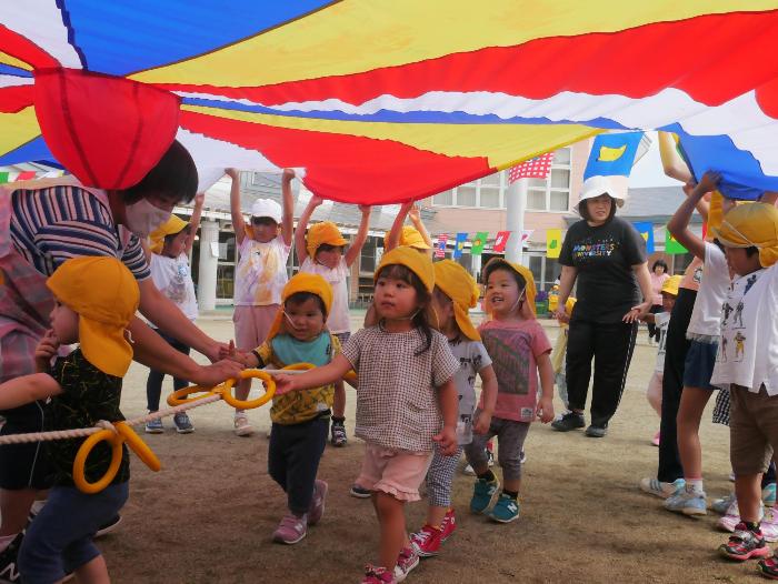 バルーンの下をくぐっているもも組の子ども