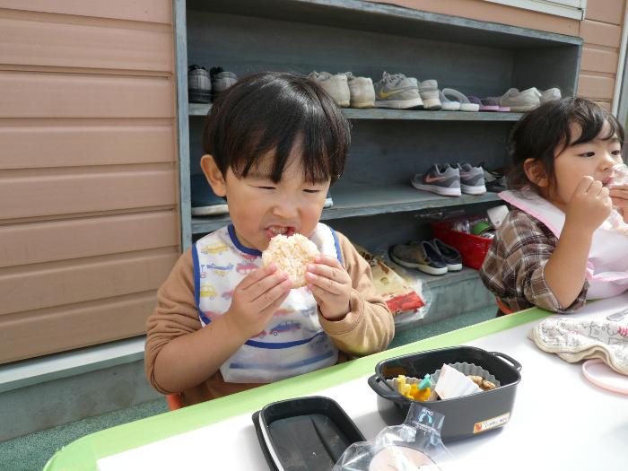 おいしそうにおにぎりを食べているの画像1