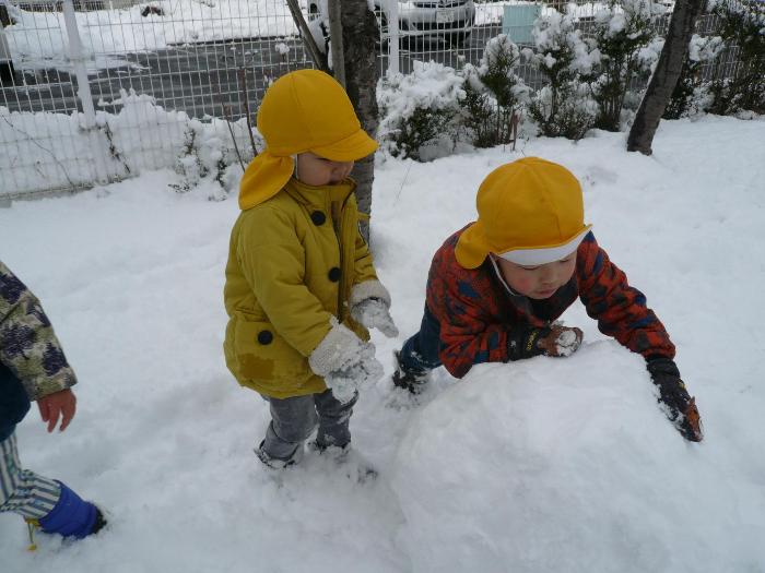 雪玉に乗って遊んでいる