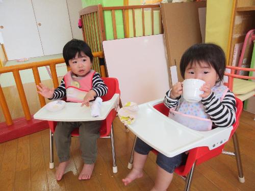 コップでジュースを飲む子ども