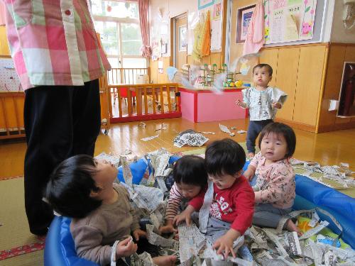 新聞紙遊びを楽しむ子どもたち