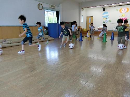 サッカーボールを蹴る子ども達