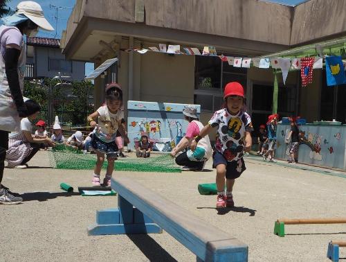 ひまわり組の子が平均台やエス棒に向かって走っている