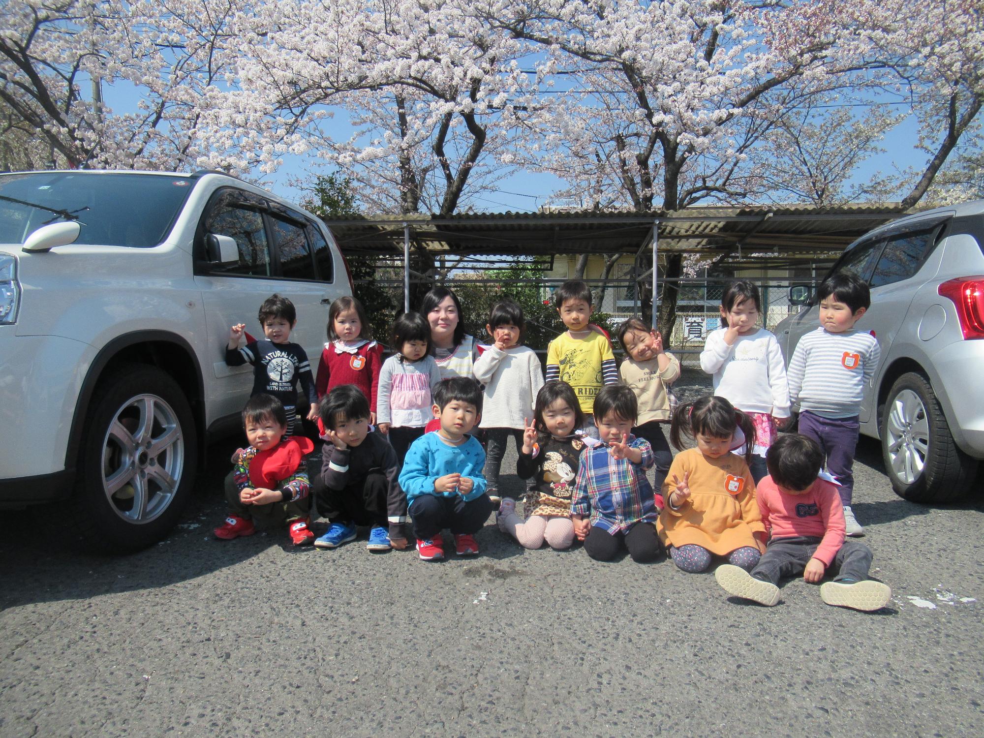 すみれ組の子供たちが桑野公民館のさくらの前で写真を撮りました