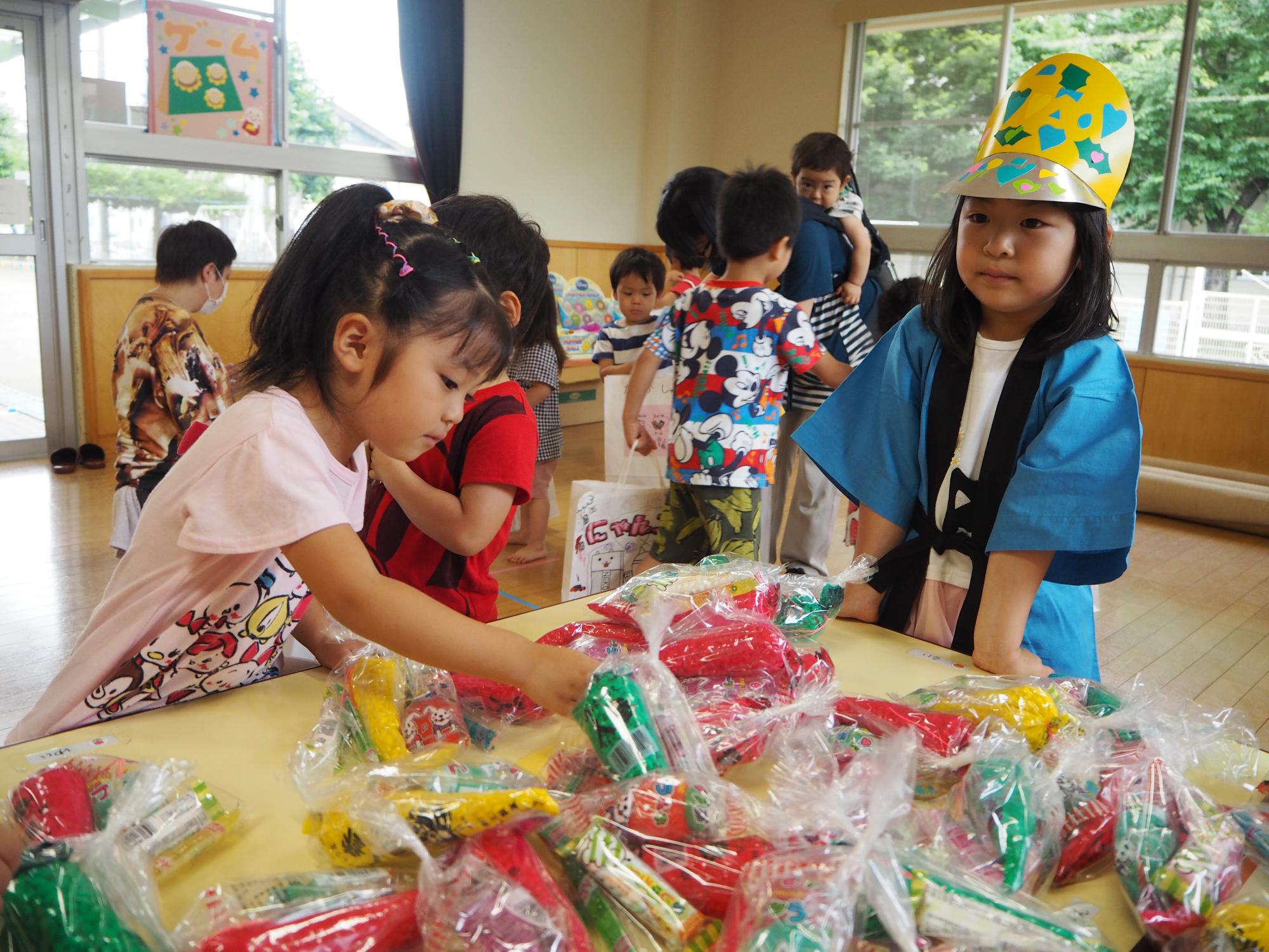 ひまわり組の子がお菓子屋さんで、お菓子を選んでいる