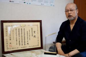 村上社長と最優秀賞受賞の賞状が写った写真