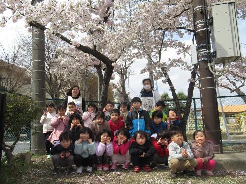 先生と一緒に桜の下で笑顔で写真をとりました
