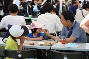 お父さんにピザを食べさせてもらう女の子