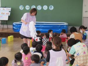 水の事故が起きないように安全祈願をする保育士と児童達