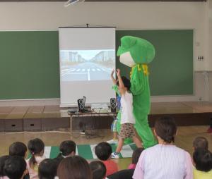 カエルの着ぐるみと横断歩道の渡り方を学んでいる児童