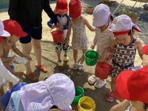 砂場に水を運んでどろんこ遊び