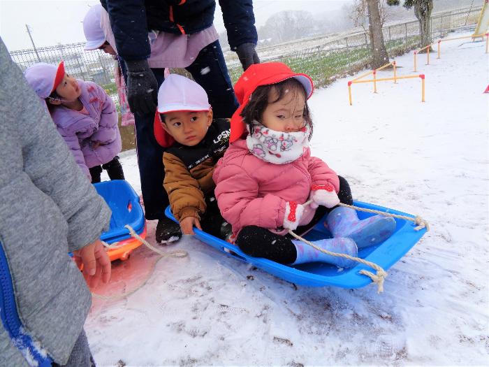 友達とそりにのる子ども