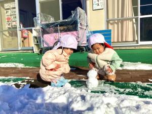 雪だるまを見つめるお友達