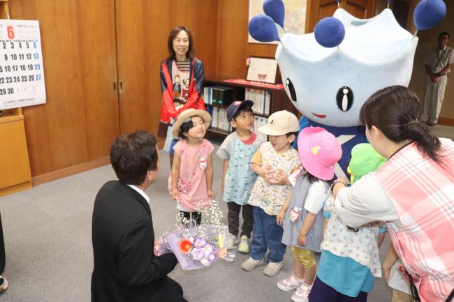 幼稚園児が花を緑川管理者に渡している様子