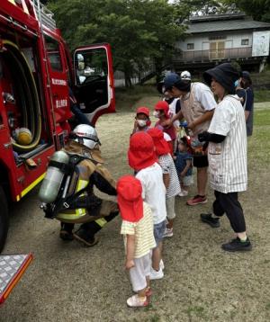 消防車を見ている保育所の児童と保育士