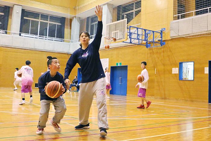 子どもにバスケットボール指導をする影山あやさんの写真