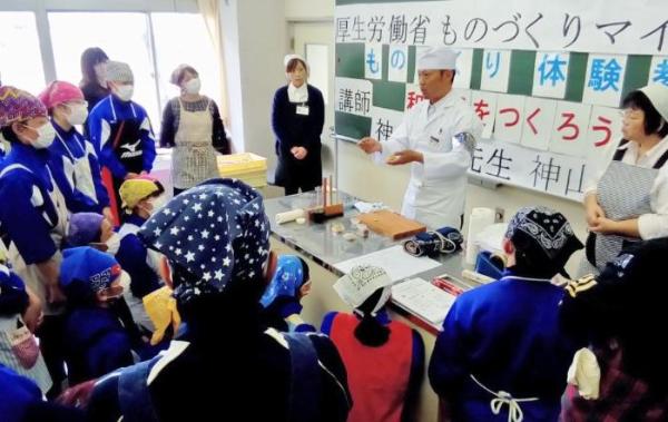 神山さんが小学校で和菓子作りを教えている画像