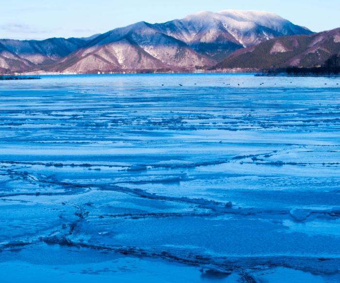 湖面が凍っている猪苗代湖の写真