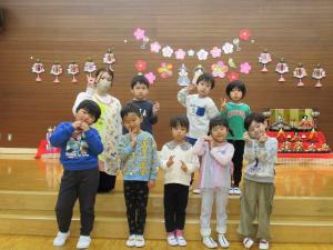 ひな人形を持って集合写真を撮るさくら組