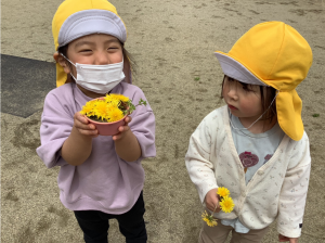 たんぽぽを使って遊んでいる子ども